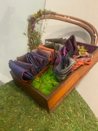 Pocket squares and ties arranged in a moss-lined styling box