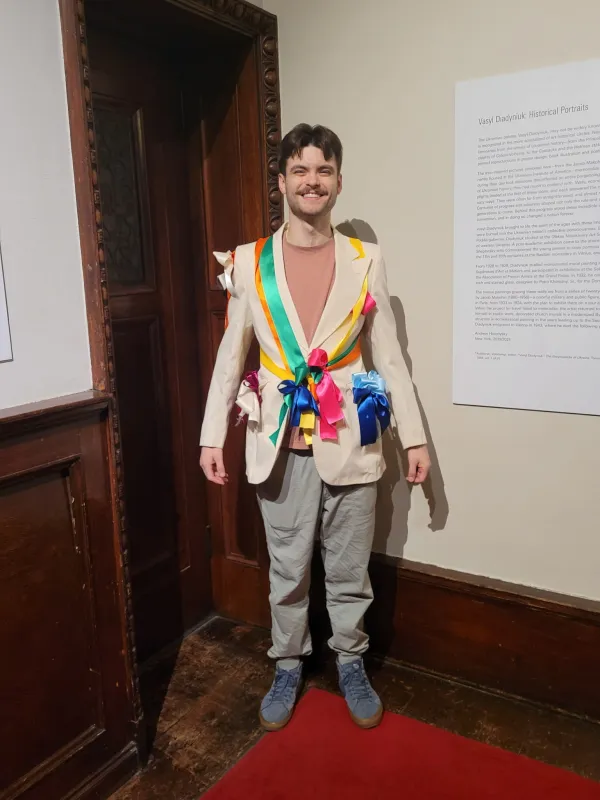 Illia George smiling in a hand-decorated ribbon blazer at the Ukrainian Institute